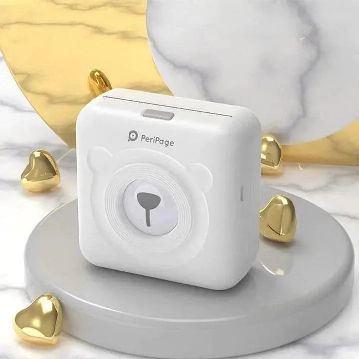 PeriPage portable mini printer with bear design on round gray pedestal with gold heart decorations