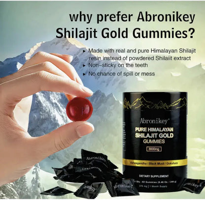 Hand holding a red shilajit gummy with Abronikey Shilajit Gold Gummies container and individual black packets