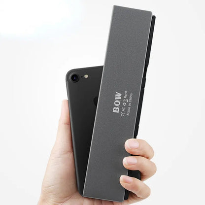Allebuy compact keyboard with bluetooth folded and held next to a smartphone for size comparison