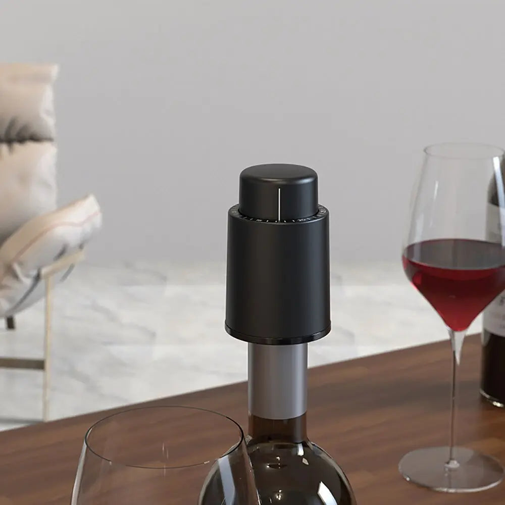 Modern black wine bottle opener on bottle next to glasses of red wine showing how to open wine with a bottle opener