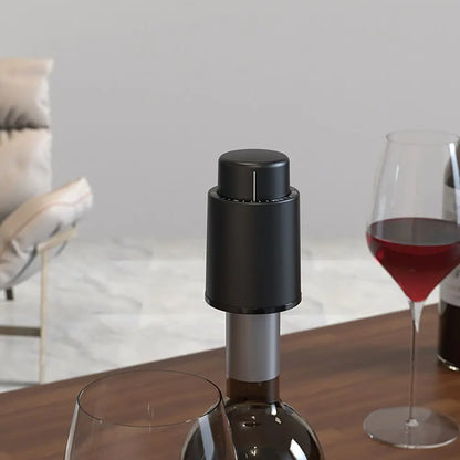 Modern black wine bottle opener on bottle next to glasses of red wine showing how to open wine with a bottle opener