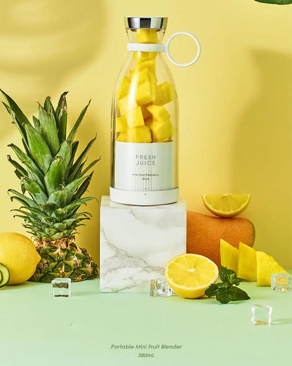 Ninja blast portable blender with fresh pineapple chunks inside on marble block surrounded by fruits