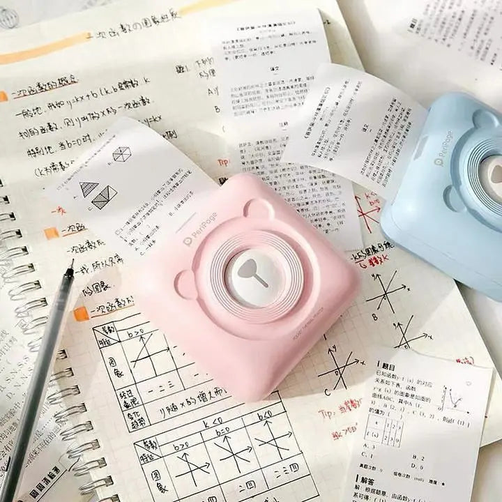Pink allebuy bambu lab a1 mini 3d printer on a notebook with handwritten notes and a pen nearby